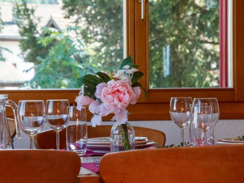 a table with glasses and a vase with flowers on it at Holiday Home Chalet Mirabelle by Interhome in Nendaz
