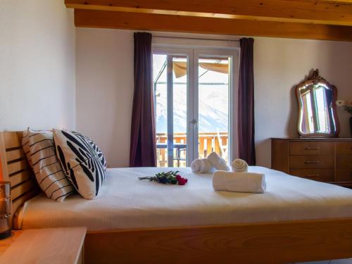 a bedroom with a large bed with a window at Holiday Home Chalet Mirabelle by Interhome in Nendaz
