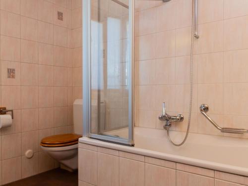 a bathroom with a toilet and a shower with a glass door at Holiday Home Chalet Mirabelle by Interhome in Nendaz