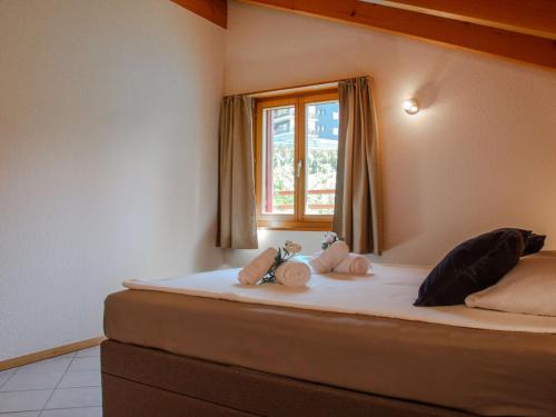 a bedroom with a bed with two stuffed animals on it at Holiday Home Chalet Mirabelle by Interhome in Nendaz