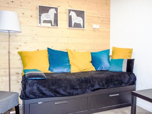 - un canapé avec des oreillers colorés dans l'établissement Apartment Le Sérac-11 by Interhome, à Val Thorens