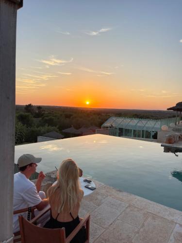 a man and a woman sitting on a patio watching the sunset at Finca Hotel Rural Es Turó in Ses Salines