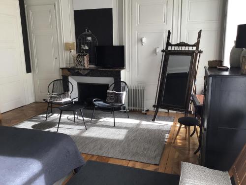 Habitación con cama, sillas y chimenea. en Une nuit au second Chambre d hôtes, en Lyon