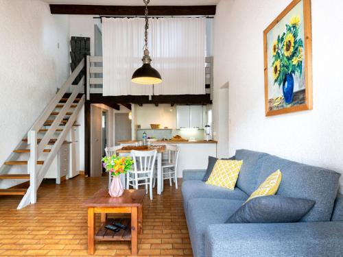 un salon avec un canapé bleu et une table dans l'établissement Apartment Hameau du courant-1 by Interhome, à Mimizan