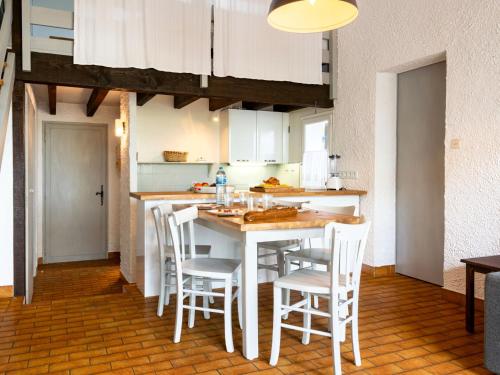 - une cuisine avec une table et des chaises blanches dans l'établissement Apartment Hameau du courant-1 by Interhome, à Mimizan