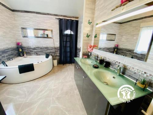 łazienka z 2 umywalkami i wanną w obiekcie Le Cosy Occitan villa chaleureuse indépendante baignoire terrasse jardin w Carcassonne