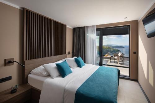 a bedroom with a large bed with a large window at Aminess Alfir Hotel in Blato