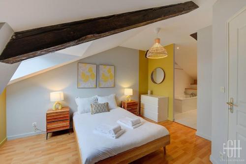 une chambre avec un lit blanc et une salle de bain dans l'établissement Le St Grégoire - Proche Centre Ville, à Tours