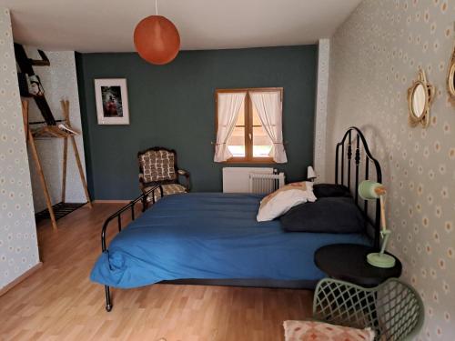 une chambre avec un lit bleu et une fenêtre dans l'établissement Charmante maison de caractère, à Passy