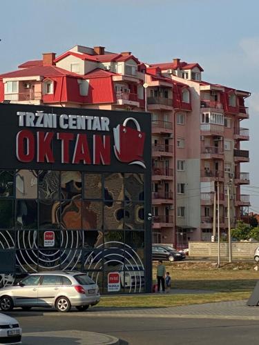 a tall apartment building with a sign for a us train at TARA apartman stan na dan in Bijeljina