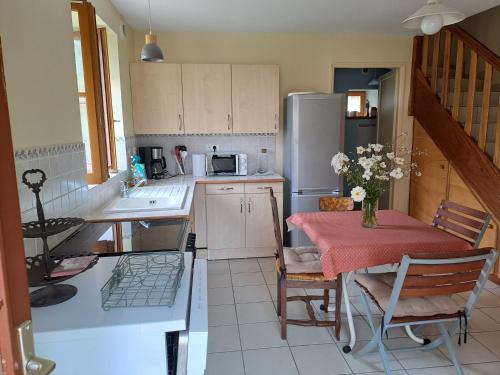 une cuisine avec une table et un réfrigérateur dans l'établissement Charmante maison de caractère, à Passy