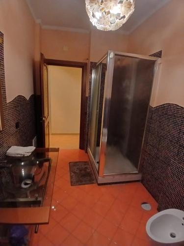 un bagno con doccia con porta in vetro di Elegante Appartamento - 20 minuti da Napoli centro a SantʼAntimo