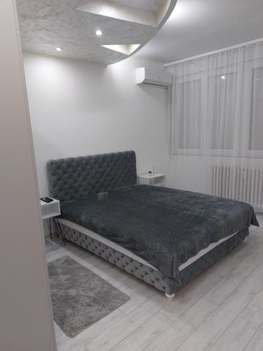 a bedroom with a large bed in a white room at Sweet home in Šabac