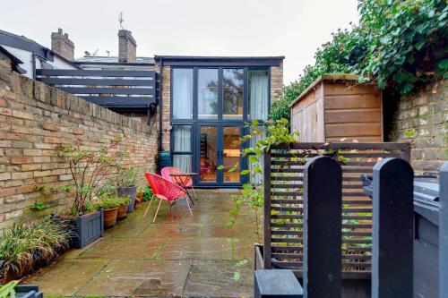 a garden with a red chair and a brick wall at 25A City Road · Luxury City centre townhouse with courtyard Pass the Keys in Cambridge