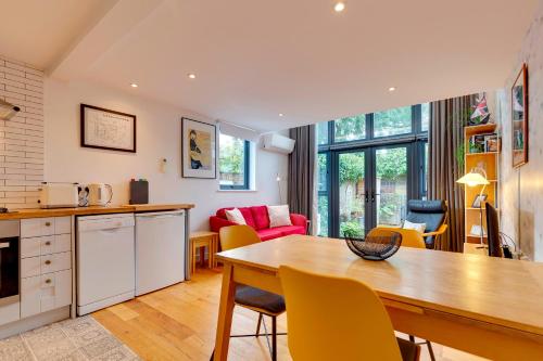 a kitchen and living room with a table and chairs at 25A City Road · Luxury City centre townhouse with courtyard Pass the Keys in Cambridge