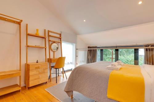 a bedroom with a yellow bed and a desk at 25A City Road · Luxury City centre townhouse with courtyard Pass the Keys in Cambridge