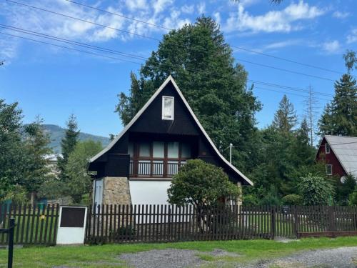 a black and white house with a fence at Chata Na Mýtině in Čeladná