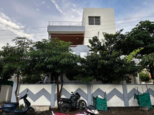 two motorcycles are parked in front of a building at Vatavriksha Guest House,Akkalkot in Akalkot