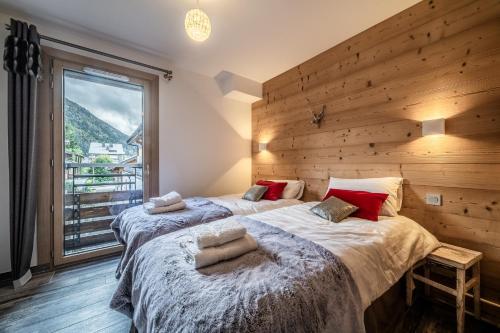 deux lits dans une chambre avec une grande fenêtre dans l'établissement PORTES DU PLENEY 203 exceptionnel T5 pour 8 personnes au pied du Pleney, à Morzine