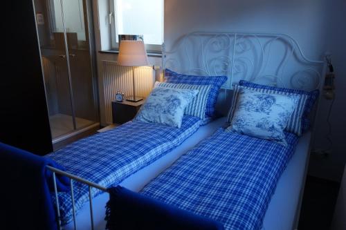 two beds in a room with blue and white pillows at Chiemgau-ROOM, helles Souterrain, eigene Terrasse in Riedering