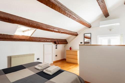 Schlafzimmer mit weißen Wänden und Holzbalken in der Unterkunft Terratetto in centro con parcheggio in Udine