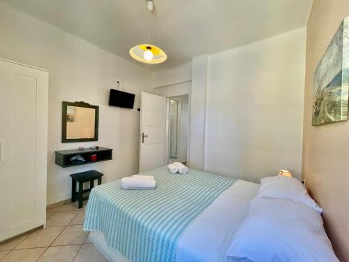 a bedroom with a bed with a blue and white blanket at Asterias Mini Coastal Apartments in Perivolos