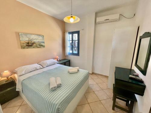 a bedroom with a bed with two towels on it at Asterias Mini Coastal Apartments in Perivolos