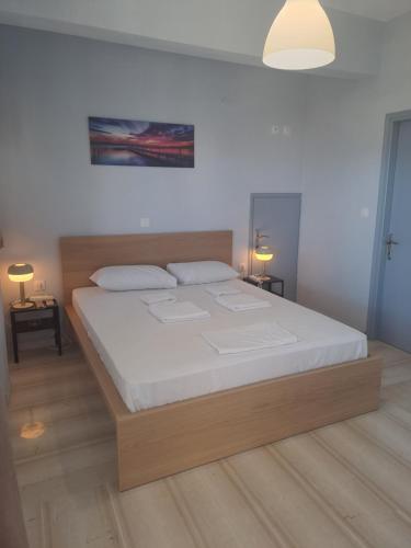 a bedroom with a large bed with white sheets at Studios Αποστόλης Selianitika in Aígio