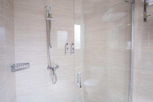 a bathroom with a shower with a glass door at Alda Cabanas Playa in Cabañas