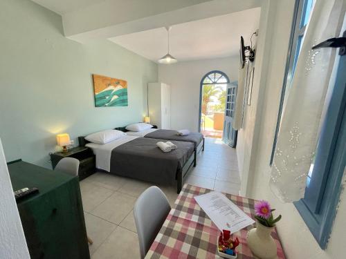 a hotel room with a bed and a table with a table sidx sidx at Asterias Mini Coastal Apartments in Perivolos