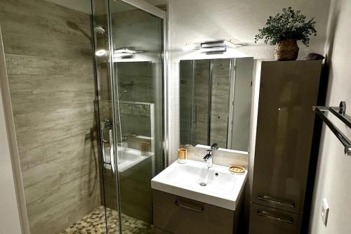 une salle de bain avec un lavabo et une douche en verre dans l'établissement 085 - Les Villégiales - 4 pers - Piscine - Golf, à La Grande Motte