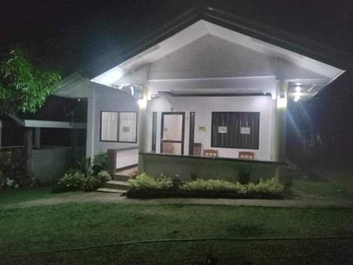 a house with lights on the front of it at night at Balai Mariacaria Pension House in Guindulman