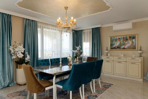 a dining room with a table and blue chairs at Villa Maria in Balchik