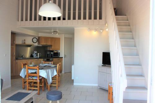 une cuisine et une salle à manger avec une table et un escalier dans l'établissement Appartement T3 climatisé avec parking privatif proche plage - 5PSOL29, à Saint Cyprien Plage