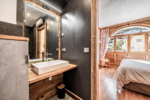 La salle de bains est pourvue d'un lavabo et d'un lit dans la chambre. dans l'établissement Lodge 1 : Magnifique deux chambres proche centre, à Morzine