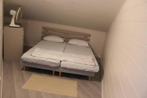 un petit lit avec deux oreillers dans une petite pièce dans l'établissement Appartement T3 climatisé avec parking privatif proche plage - 5PSOL29, à Saint Cyprien Plage