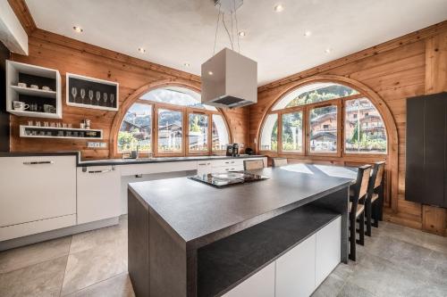 - une cuisine avec des murs en bois et un grand îlot dans l'établissement Lodge 1 : Magnifique deux chambres proche centre, à Morzine
