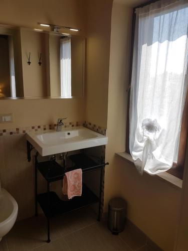 a bathroom with a sink and a mirror and a window at Podere Gabry in Arena Metato