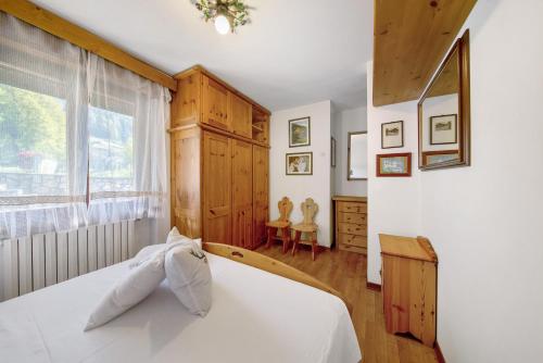 a bedroom with a white bed and a window at Appartamento Privato Nelle Dolomiti in Vodo Cadore
