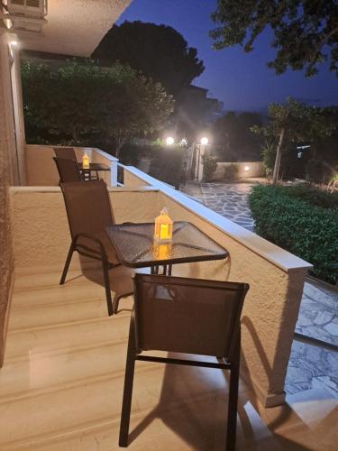 a patio with chairs and a table and a candle at Studios Αποστόλης Selianitika in Aígio