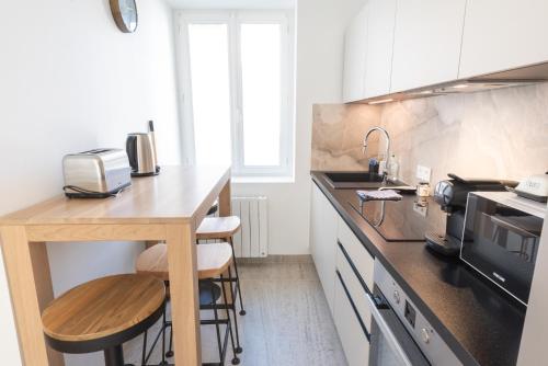 une cuisine avec un comptoir avec un évier et un micro-ondes dans l'établissement PREMIUM T2 neuf 2ème étage ultra Centre Lorient par Groom, à Lorient