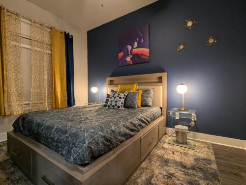 a bedroom with a large bed and a blue wall at The Apollo - Lux 1-Bed Apartment near Space Center in Houston