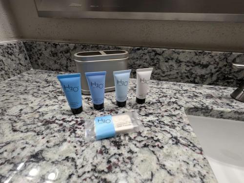 a group of three cups on a bathroom counter at The Artemis - 1 Bd Apt near JSC in Houston