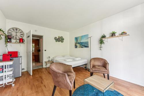 - un salon avec un lit et deux chaises dans l'établissement Chic studio Champs-élysées, à Paris