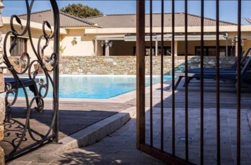 une clôture avec un banc en face d'une piscine dans l'établissement Soleil, Piscine, Parking et Bienvenue à Sisco, à Sisco