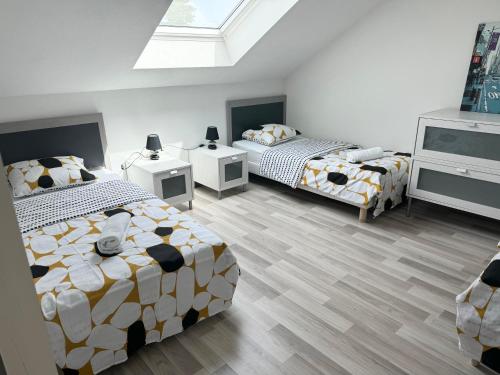 - une chambre avec 2 lits et une lucarne dans l'établissement Appartement Bes,, Attique neuf avec confort, à Wittenheim