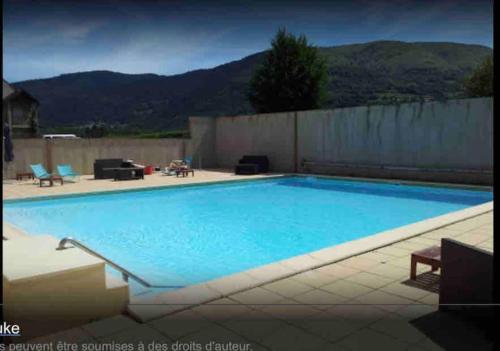 a large blue swimming pool with mountains in the background at T2 Cabine 4 à 6 pers Vue Montagne et Piscine in Vignec