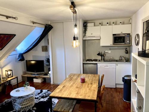 a living room with a wooden table and a kitchen at T2 Cabine 4 à 6 pers Vue Montagne et Piscine in Vignec