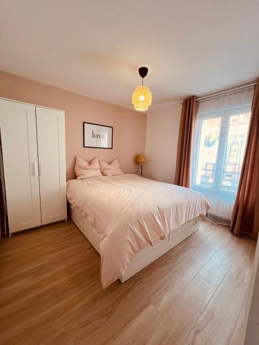 une chambre avec un grand lit et une fenêtre dans l'établissement Proche Paris & Stade De France & Adidas Arena, à Saint-Denis