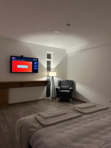 a room with a bed and a tv on the wall at Janjić Apartmani in Zvornik